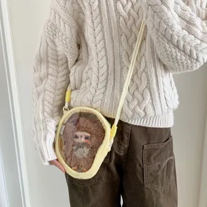 Close-up of a yellow plush doll display bag with a clear window worn on a model.
