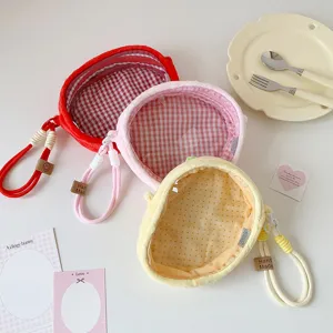 Close-up of three plush transparent doll display bags in red, pink, and yellow colors