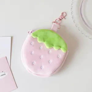 Macro view of a cute pink plush strawberry shaped coin purse with a matching pink swivel hook