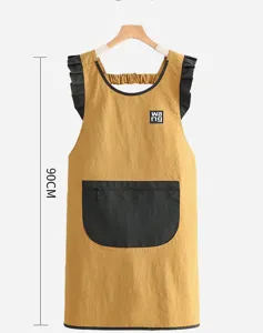 Detail view of the yellow kitchen apron with black ruffled straps and front pocket 90cm