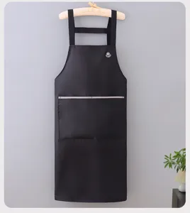 Black waterproof kitchen apron detail, hanging view with chest pocket and badge design.