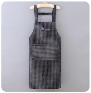 Detailed view of a black and white checkered kitchen apron with front pocket and cute bear.
