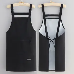 Black waterproof kitchen apron with cross back straps, zipper pocket, ideal for cooking.