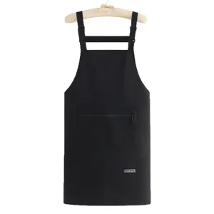 Black waterproof kitchen apron with pockets and adjustable straps for cooking and catering work.