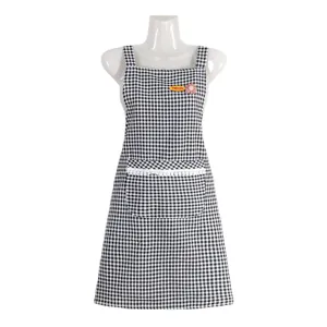 Tablier de cuisine à carreaux noir et blanc avec poche avant et jolie bordure en dentelle.