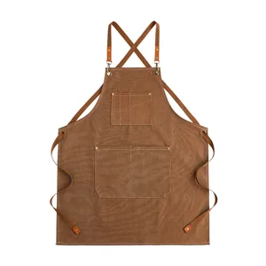 Grembiule in tela marrone spesso con spallacci incrociati e tasche utili per cucina e giardinaggio.