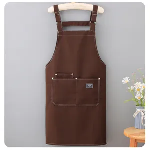 Brown canvas kitchen apron detail showing durable strap and pocket design with contrast stitch