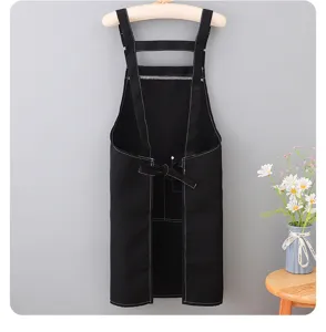 Black canvas apron detail view, sleeveless strap design with white stitching, workwear.