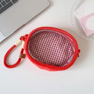 Detail view of red plush doll display bag with transparent window and gingham lining