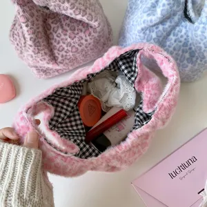 Close-up of leopard print plush cosmetic bag showing interior storage with makeup