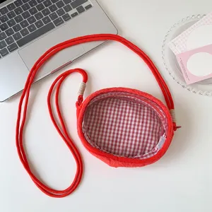 Detailed close-up view of the red plush doll display bag with checkered lining