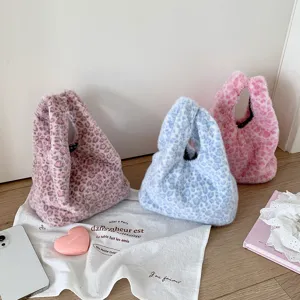 Close-up of soft plush leopard print handbags in pastel pink and blue colors.