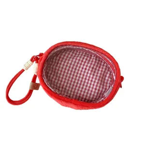 Red plush doll display storage bag with red and white checkered interior lining and strap