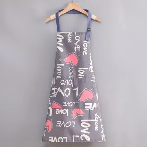 Detalle en primer plano del delantal de cocina de lona gris con estampado de corazones.