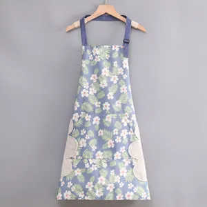 Detalle de delantal de cocina floral de lona con tirantes ajustables y paños laterales prácticos.
