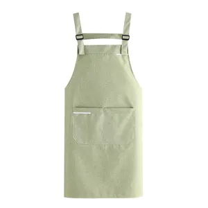 Green kitchen apron with pockets and adjustable straps, perfect for cooking, baking, and housework.