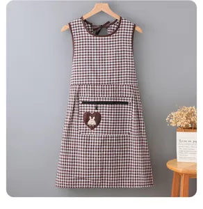 Detailed view of the brown checkered kitchen apron featuring a zipper pocket and cute rabbit patch.