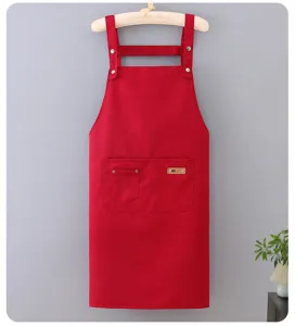 Red work apron detail view, durable poly-cotton fabric with adjustable straps and pocket.