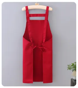 Red kitchen apron with H-shaped straps, durable fabric for cooking and baking tasks.