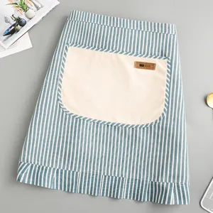 Blue and white striped half apron with large beige front pocket and ruffled hem for kitchen.