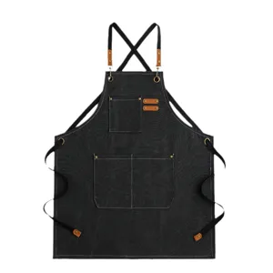 Schwarze Jeans Canvas Arbeitschuerze mit Kreuzgurt Taschen und Lederdetails fuer Koch