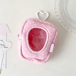 Close-up detail view of pink polka dot plush doll storage bag with heart window and hook