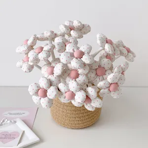 Close-up of fabric flower-shaped gift pens with pink polka dots in a woven basket