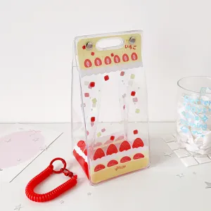 Close-up of strawberry cake patterned PVC doll display bag with red coil keychain accessory