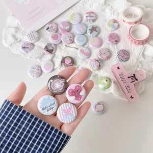 Hand holding assorted cute 25mm mini cartoon button badges for backpack decoration