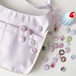 Detail view of various 25mm cute cartoon badges pinned on a lilac canvas bag