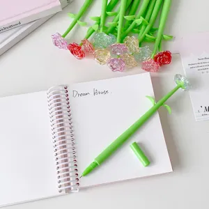 Macro detail of a creative rose-shaped gel pen resting on an open spiral notebook.