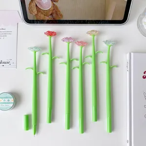 Close-up detail of creative crystal rose flower gel pens with green stems on white desk.