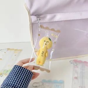 Clear PVC mini doll display pouch hanging on a purple backpack as a charm decoration
