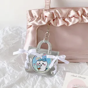 Silver ballet-style handbag badge holder with white ribbons and a clear display window