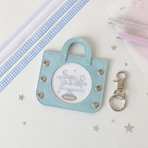 Close-up of a light blue coquette style badge display bag with a circular window.