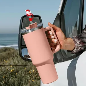 Tumbler isotherme rose avec poignée et adorable embout de paille Père Noël en détail.