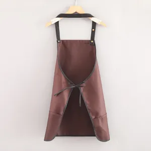 Short brown kitchen apron with black straps and pockets, perfect for cooking and restaurant work.