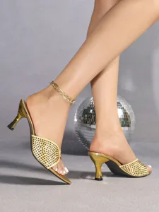 Gouden hoge hakken met strass en puntige neus detailopname, perfect voor feestjes.