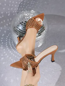 Detailaufnahme von braunen gewebten Stiletto-Sandaletten mit Absatz und offener Zehenpartie.