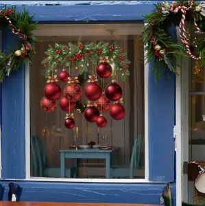 Détail d'un sticker de fenêtre de Noël festif avec boules rouges et branches de pin