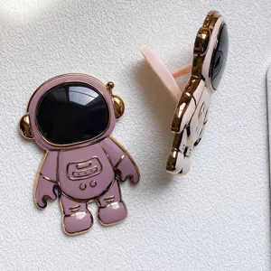 Nahaufnahme des niedlichen 3D-Astronauten-Handyhalters mit rosa und goldenem Metall-Finish.