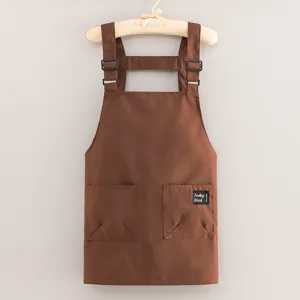 Tablier de travail marron en toile avec bretelles réglables et poches pour cuisine et boulangerie.