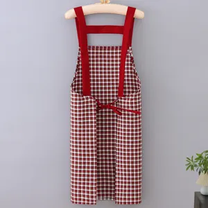 Red and white plaid kitchen apron with wide red straps and back ties, clean hanging view.