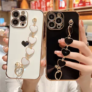Luxury electroplated wrist chain phone case with heart charms for iPhone, elegant black and white.