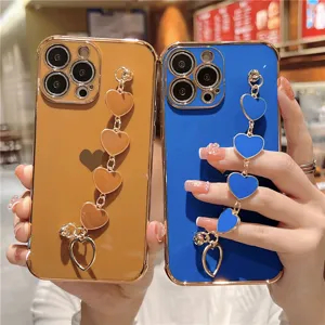Detailed view of luxury electroplated phone case with cute heart bracelet wrist chain.