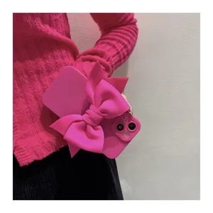 Close-up detail of hot pink phone case featuring a large fabric bow, elegant and trendy.
