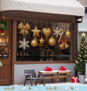 Detail of golden Christmas window stickers with festive bells, stars and snowflakes.