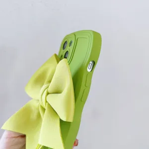 Dettaglio della custodia in silicone verde con grande fiocco in tessuto e onde.
