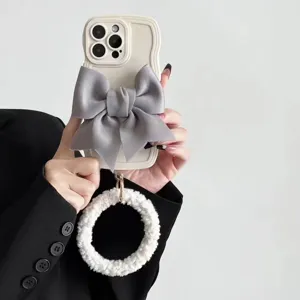 Elegant wavy phone case featuring a large grey satin bow and fluffy plush wrist strap ring.