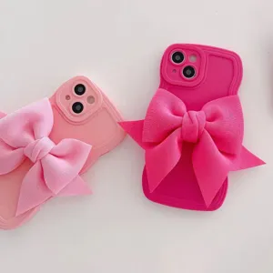Vista dettaglio cover telefono fiocco rosa, materiale silicone morbido con grande fiocco in stoffa.
